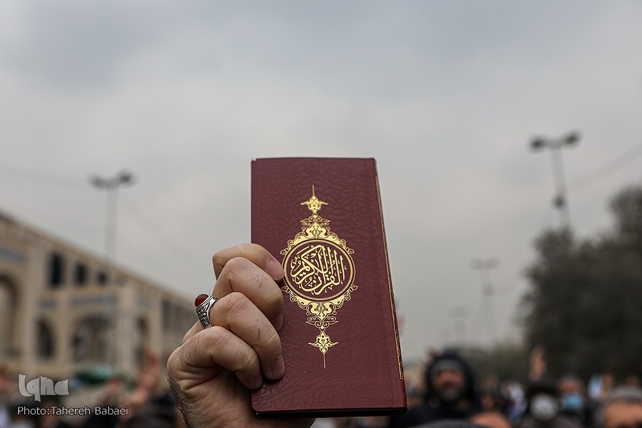 A protestor holds raises a copy of the Holy Quran during rallies against Quran desecration in European countries on Jan. 27, 2023, in Tehran. (Photo by IQNA)